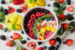 A vibrant, healthy fruit smoothie bowl topped with fresh berries, mango, and almonds.