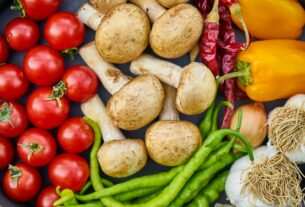 A vibrant assortment of fresh vegetables and mushrooms arranged in a flat lay.